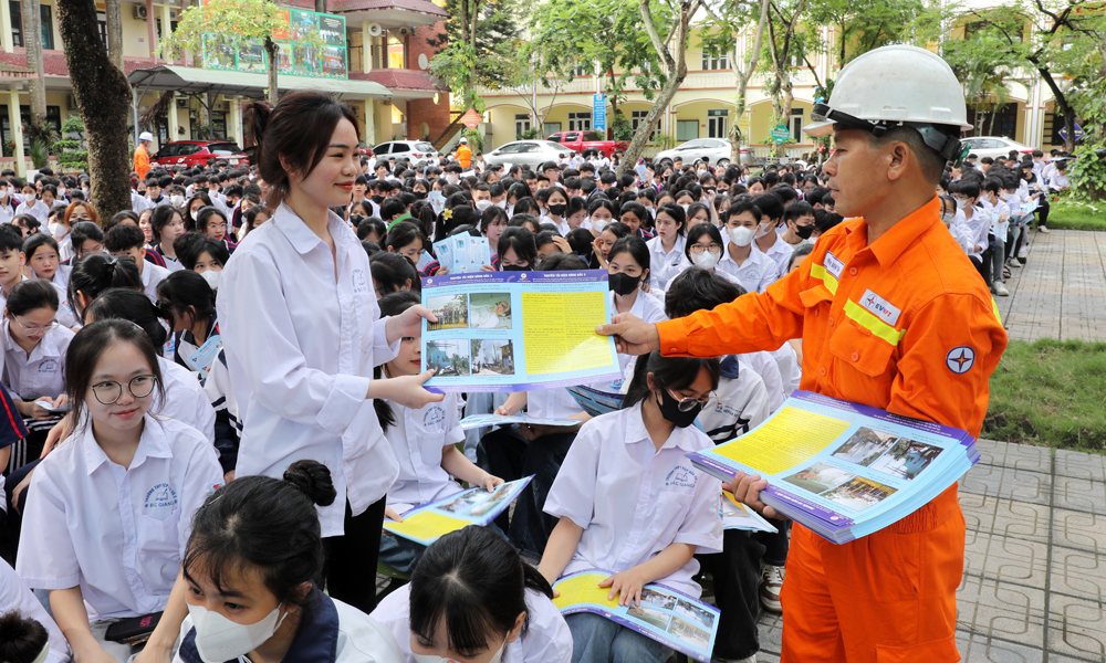 Công nhân Điện lực Hiệp Hòa phát tờ rơi tuyên truyền bảo vệ HLATLĐ tại Trường THPT Hiệp Hòa số 2.